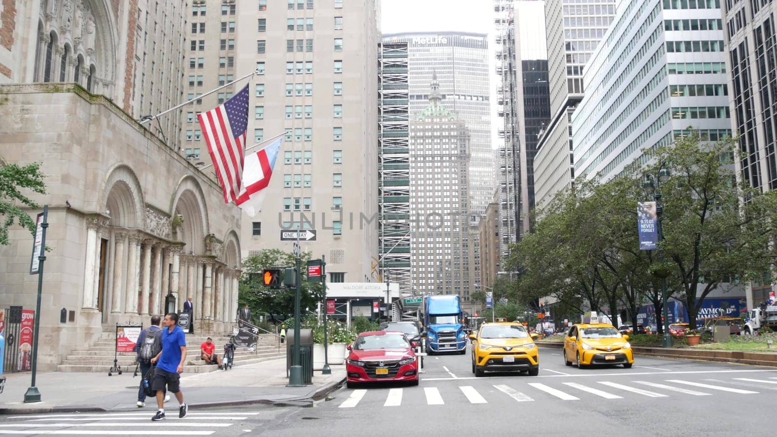 New York City, United States - 11 Sept 2023: Manhattan Midtown street, Park avenue crossroad intersection. Urban road car traffic in USA. People pedestrians, zebra crosswalk. Yellow taxi cab. MetLife.