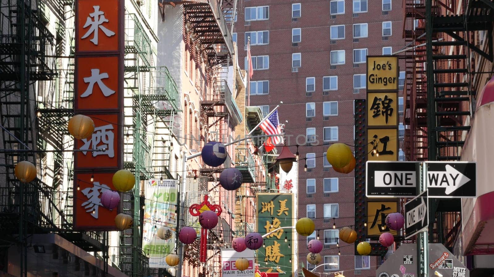 New York City, United States - 14 Sept 2023: Manhattan Chinatown Pell street. Chinese culture, ethnic district architecture, USA. Red brick buildings, paper lanterns and hieroglyph signs. Little China