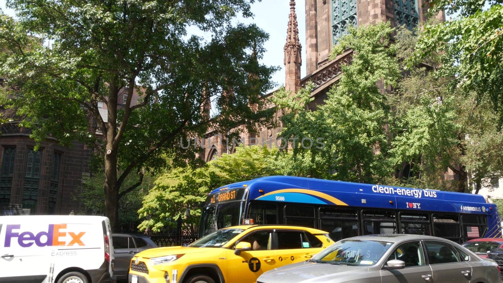New York City, United States - 8 Sept 2023: Manhattan Greenwich Village street, 5th Fifth 5 avenue. American urban road car traffic. Yellow taxi cab, USA. Fedex car near The First Presbyterian Church.