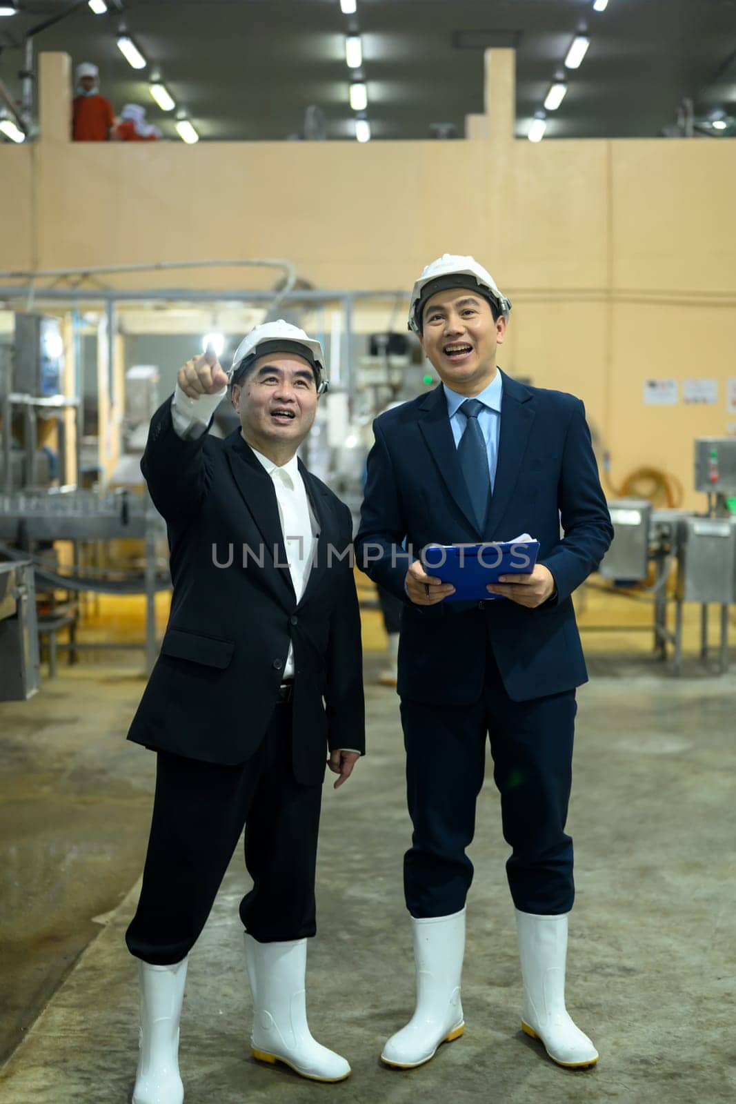 Two factory executives discussing operations inside a food manufacturing facility.