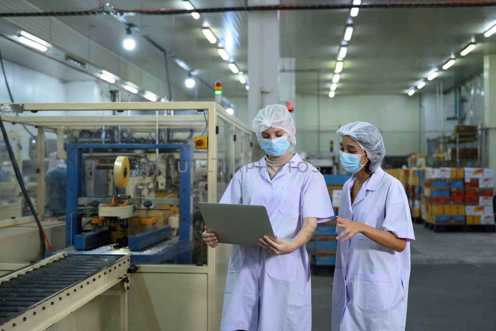 Food factory staff reviewing production data in a food packaging facility.