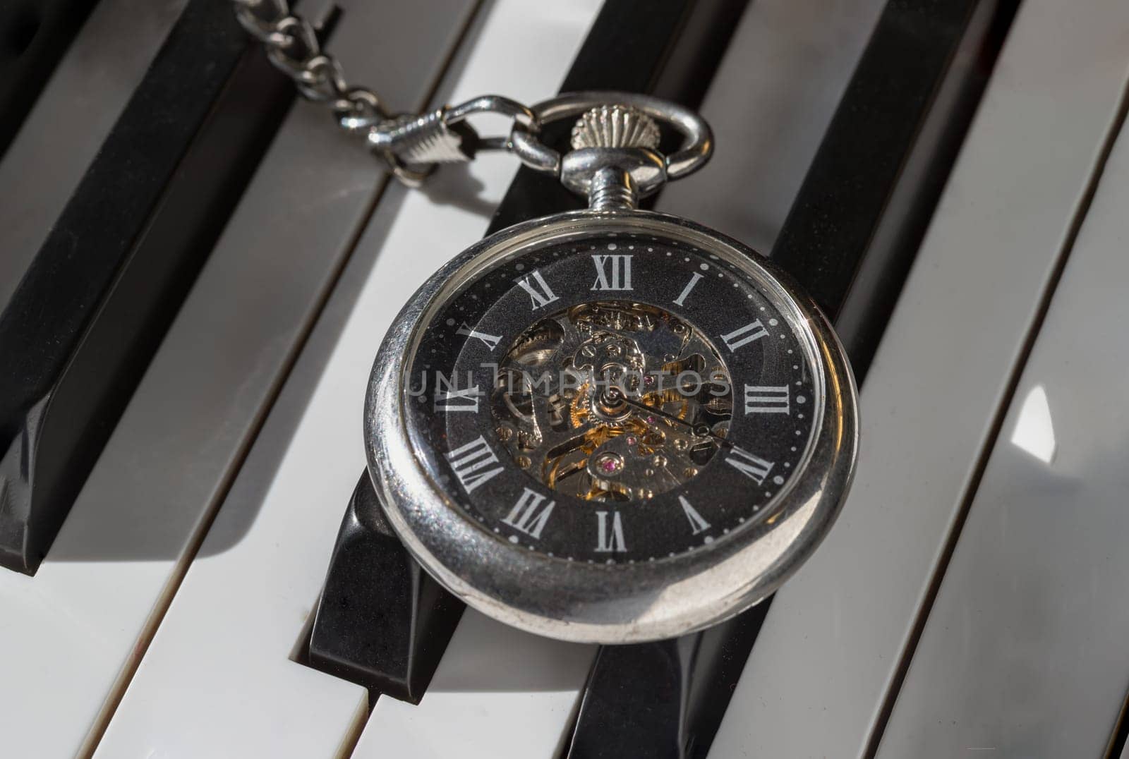 London, UK - Apr 19, 2025 - Antique pocket watch or Retro pocket watch on Piano keys background. "keys and time" use it as your Wallpaper, Poster and Space for text, Selective focus.