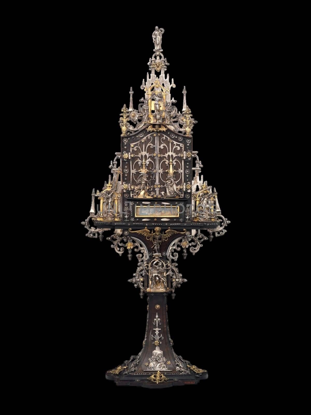 this detailed antique shrine showcases intricate gold and silver metalwork, embodying a gothic and historical aesthetic. the ornate religious artifact rests on an elegant pedestal, highlighting its craftsmanship and sacred significance. perfect for collectors of religious art and historical artifacts.