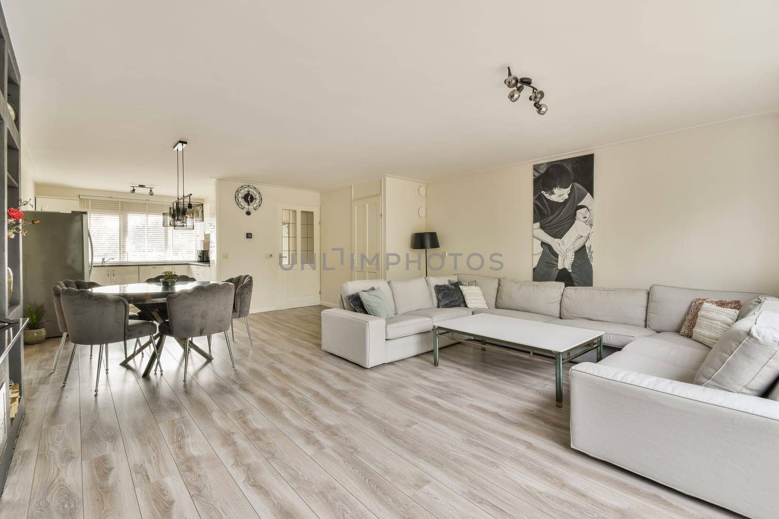 Stylish modern living room featuring a cozy sofa, elegant lighting, and a chic dining area, creating a welcoming ambiance for relaxation and social gatherings.