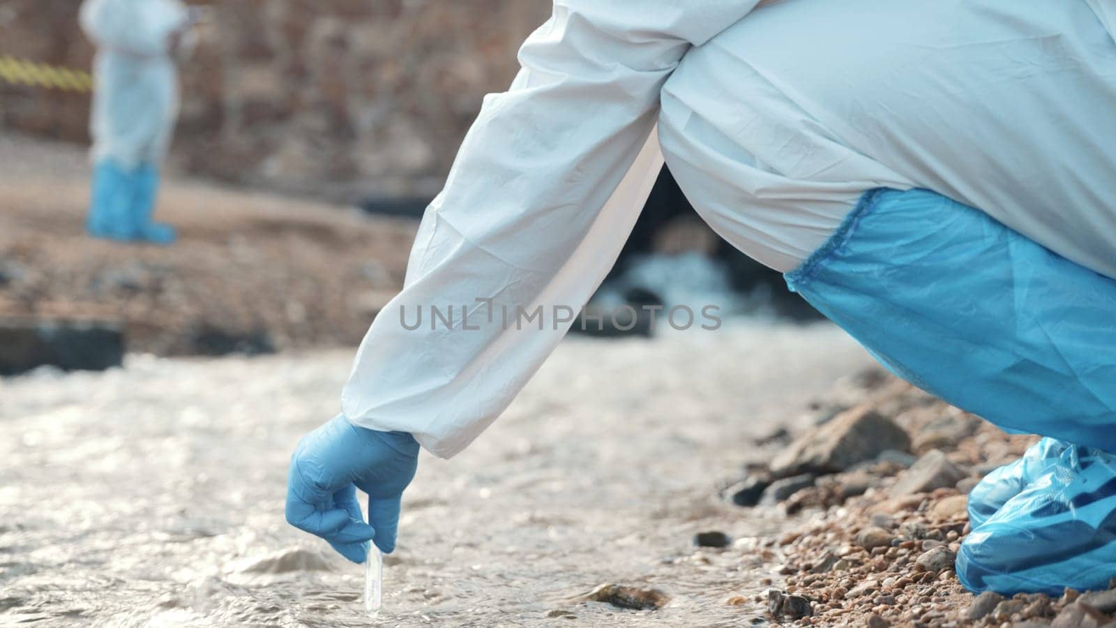 Ecologist sampling water from the river with test tube, Biologist wear protective suit and mask collects sample of waste water from industrial, problem environment, scientist environmentalist