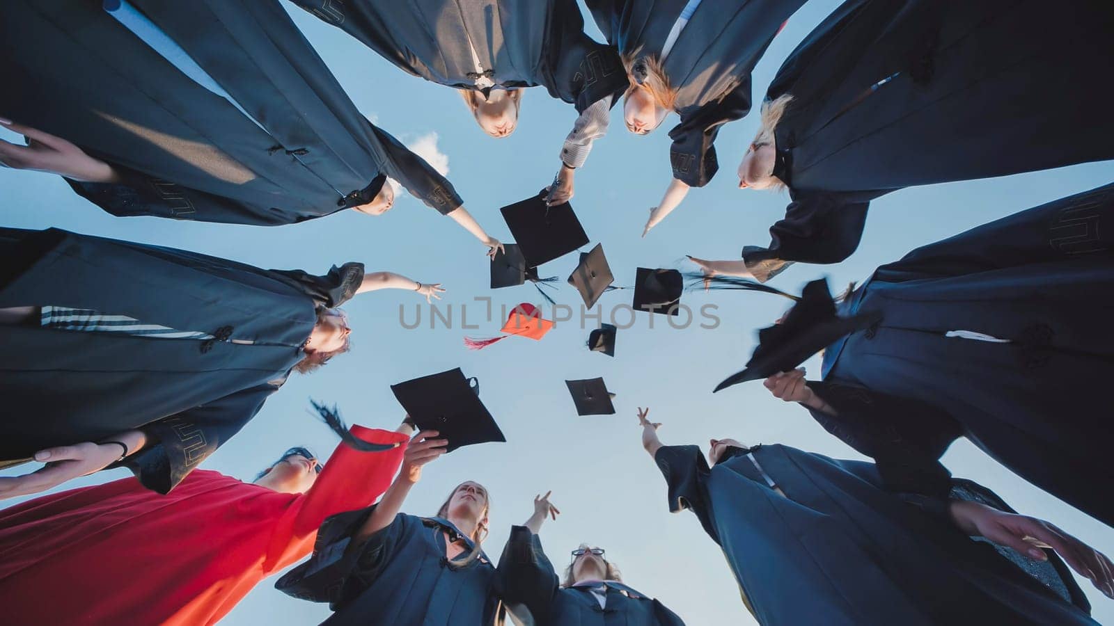 Group of cheerful graduates tossing their graduation caps into the sky, celebrating their academic success and the end of their studies