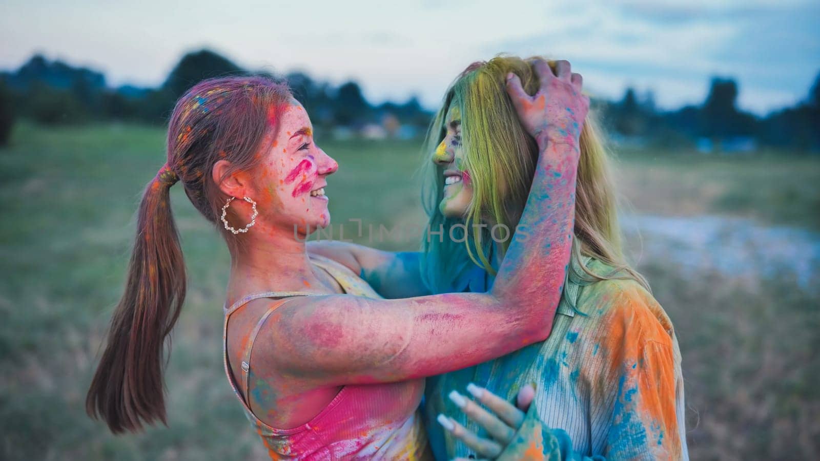 Two joyful school friends embracing, adorned in colorful holi powder paint, commemorating friendship and happiness at the vibrant festival