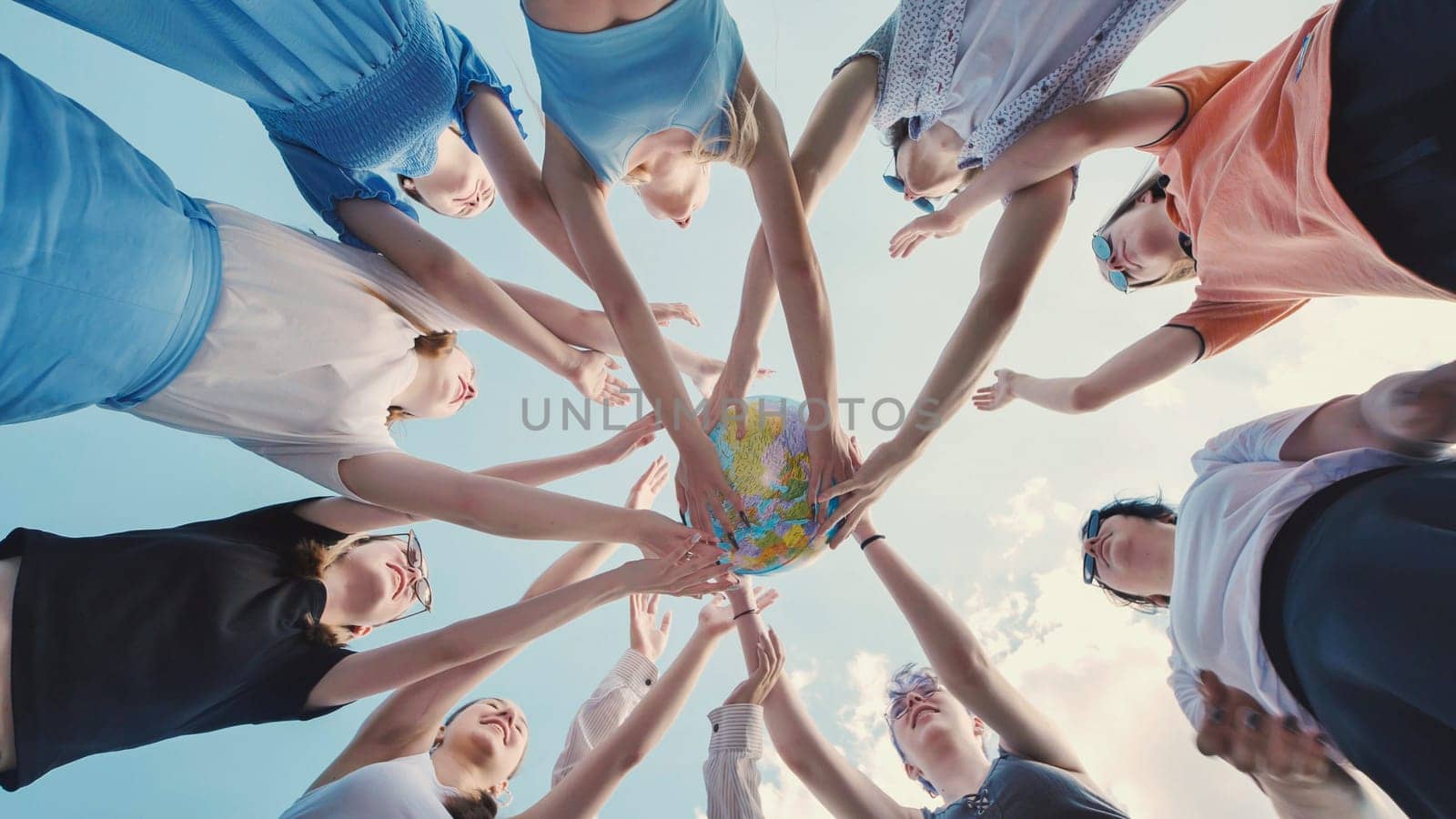 School friends joining hands around a globe, symbolizing unity and commitment to environmental protection and sustainability