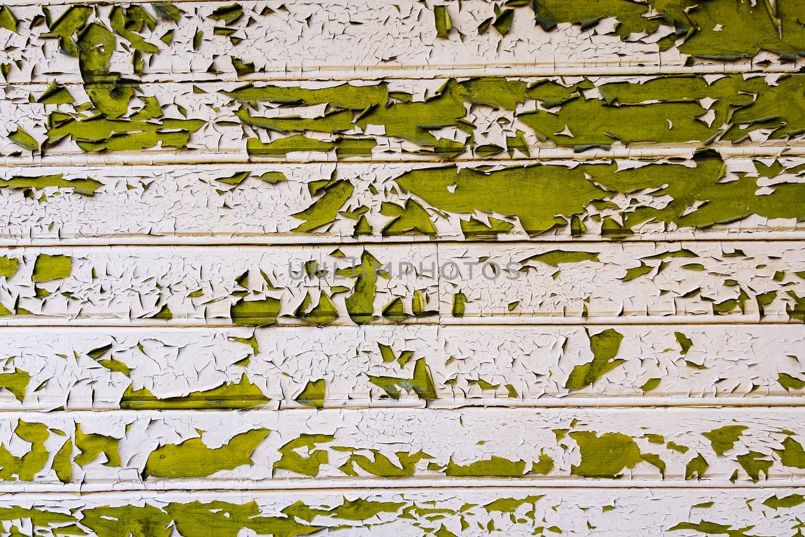 Peeling green paint on white wooden planks creates a textured, weathered background, ideal for grunge or vintage projects