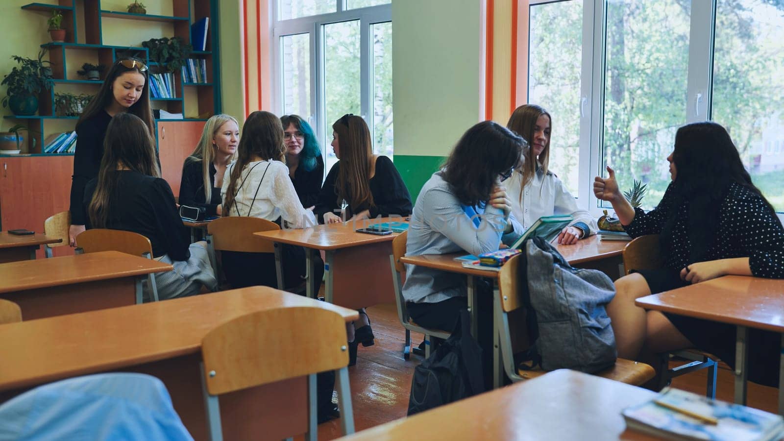 High school students working together in a well lit classroom, participating in discussions and exchanging ideas while completing group assignments