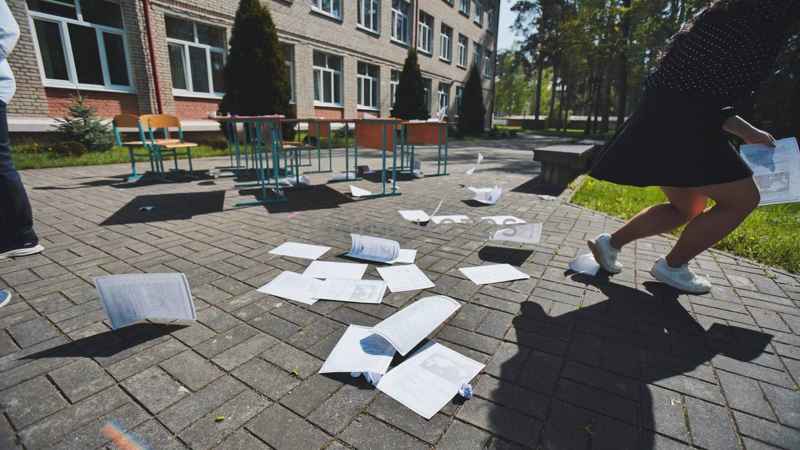 School is out, and students are throwing exam papers in the air, celebrating the end of the school year