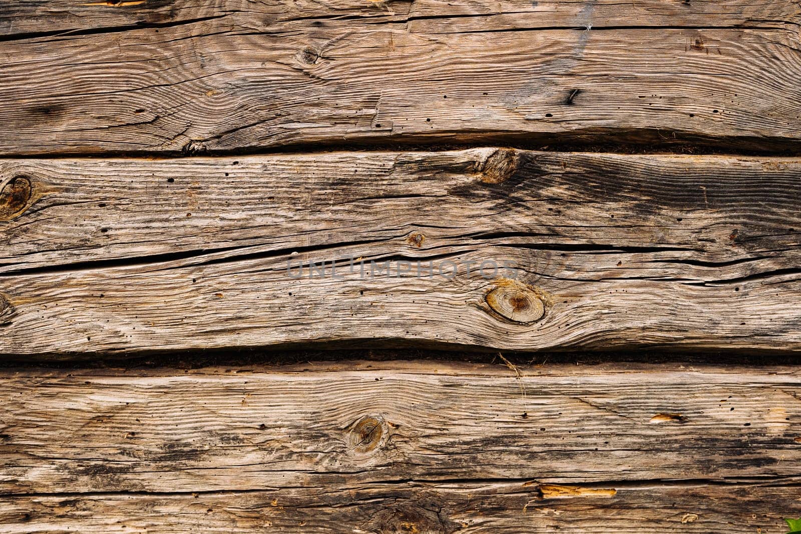 Horizontal wooden planks forming a textured surface with cracks and knots