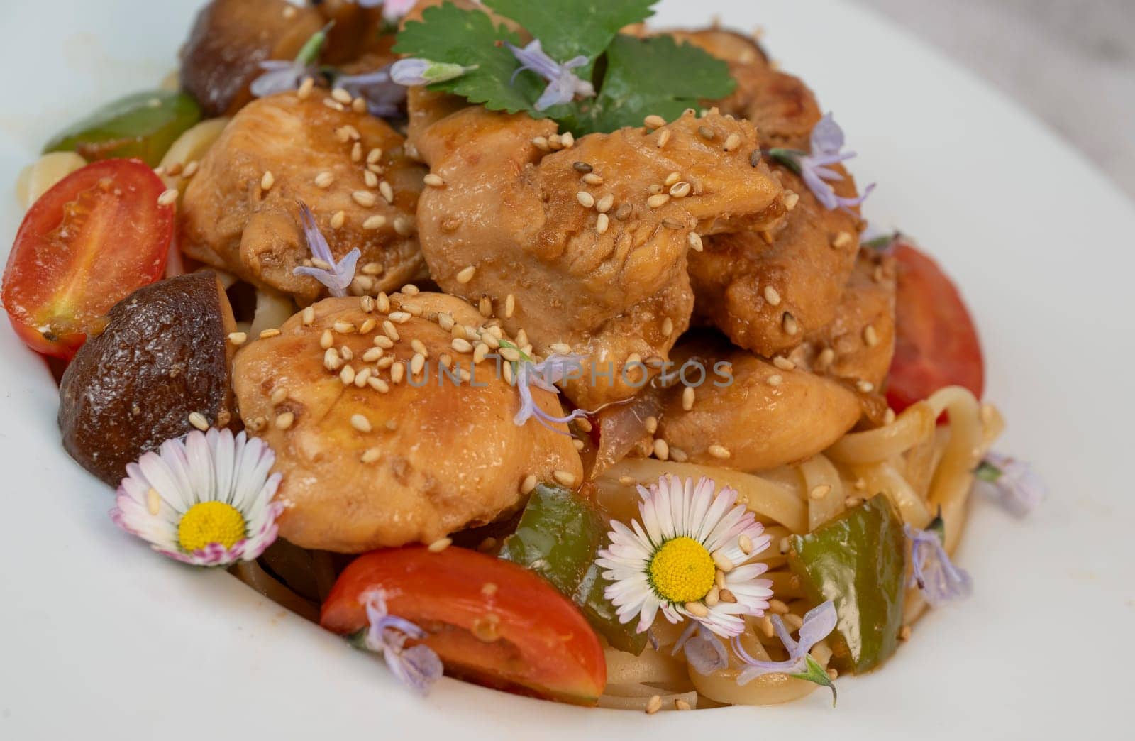 A flavorful blend of chicken, linguine, shiitake mushrooms, bell peppers, and fresh garden flowers offers a vibrant and appetizing meal. Ideal for a cozy dinner or gathering.