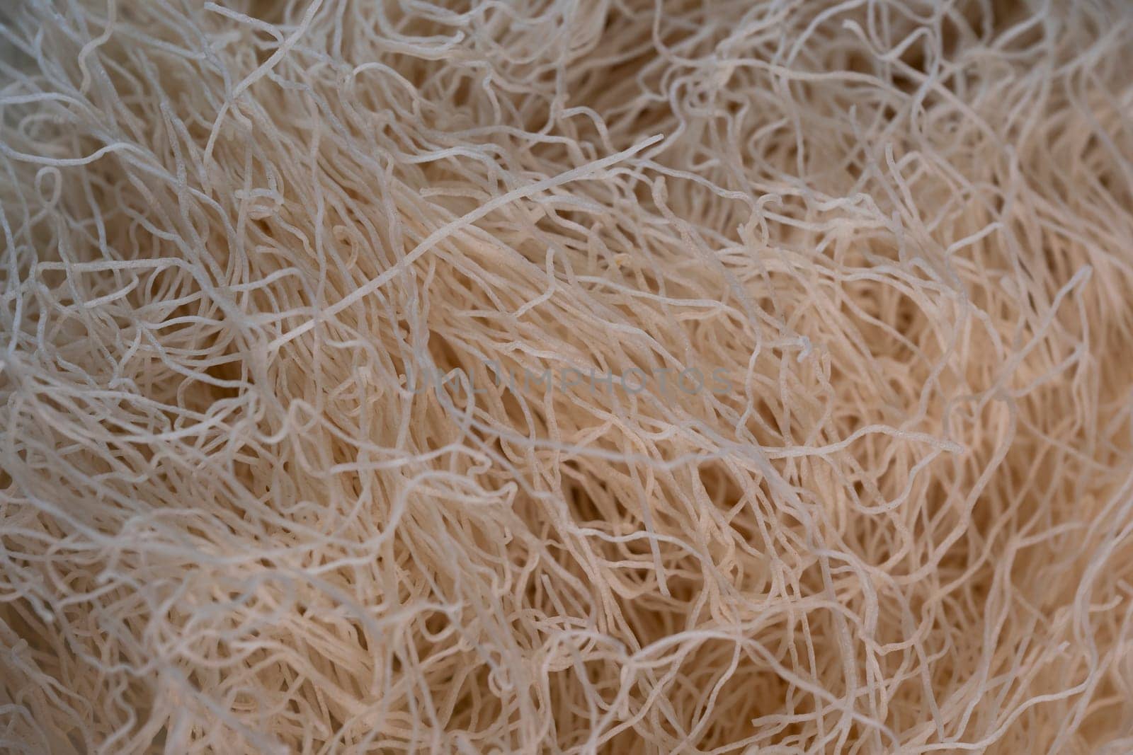 Delicate strands of kadaif are showcased in a lively kitchen, ready to be incorporated into a delicious traditional dessert. The warm lighting enhances the texture of the dough.
