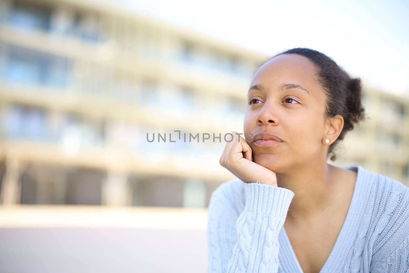 Black woman thinking looking away in the street