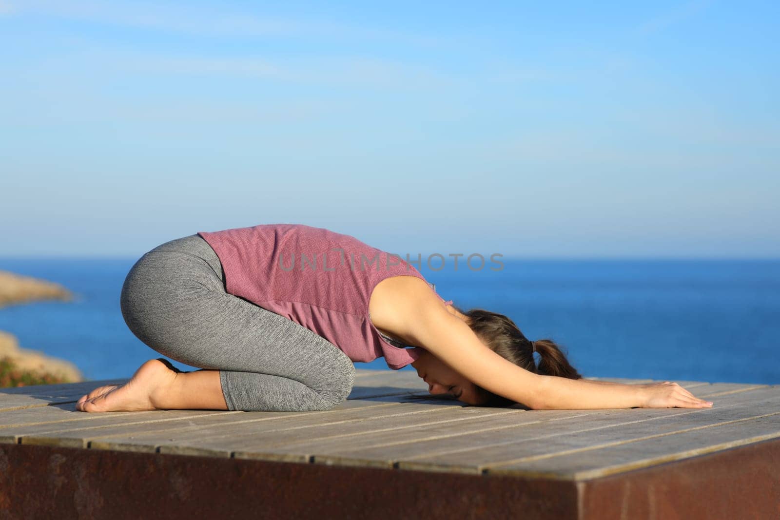 Profile of a woman doing yoga on the beach