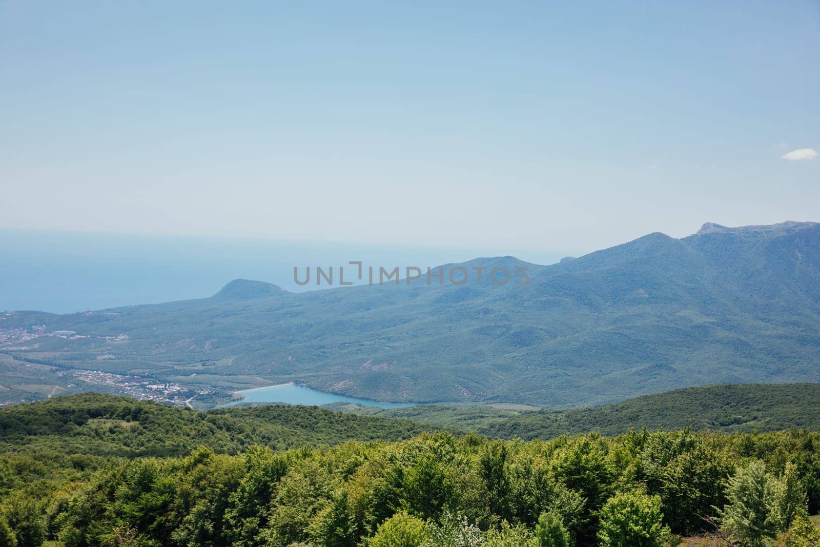 Beautiful landscape on green forest mountains and blue sky from the top of the cliff
