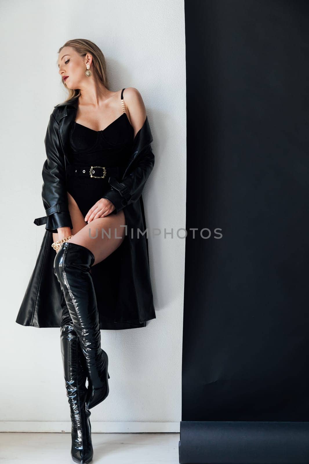 Fashionable slim woman in black leather raincoat and boots