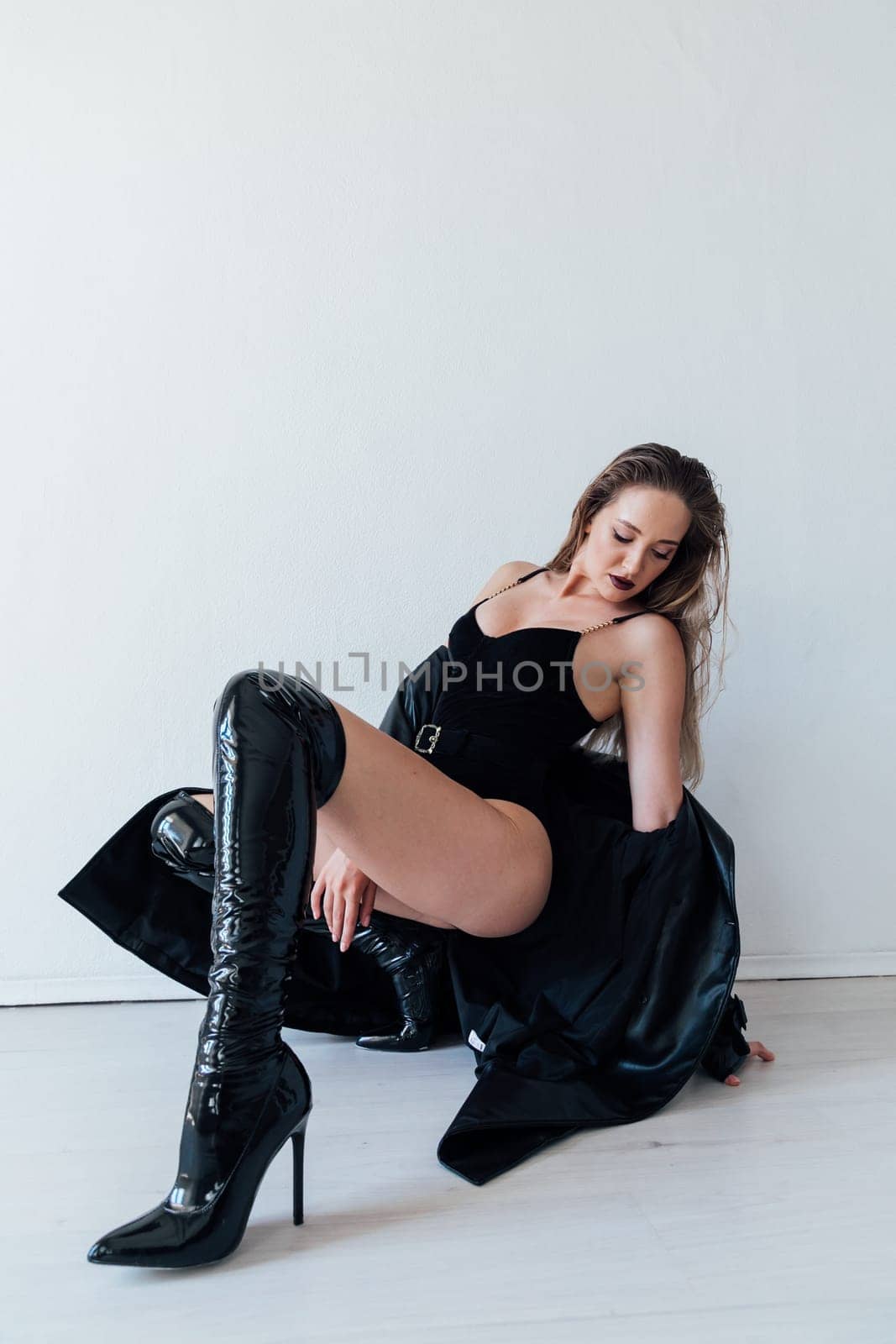 Fashionable slim woman in black leather raincoat and boots