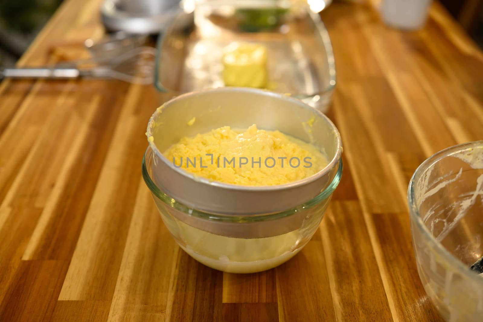 Close up of butter and buttermilk separation on wooden countertop.