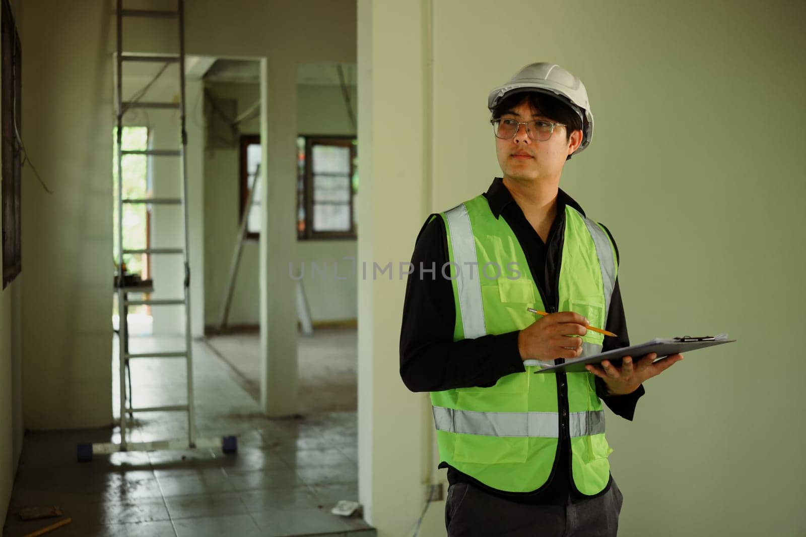 Construction supervisor evaluating site progress and noting observations during walkthrough.
