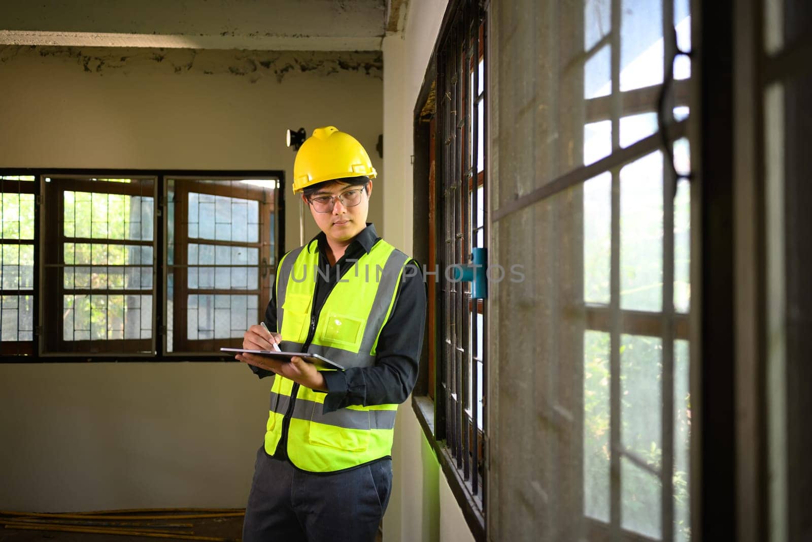 Site supervisor using digital tablet to inspect and manage residential construction.