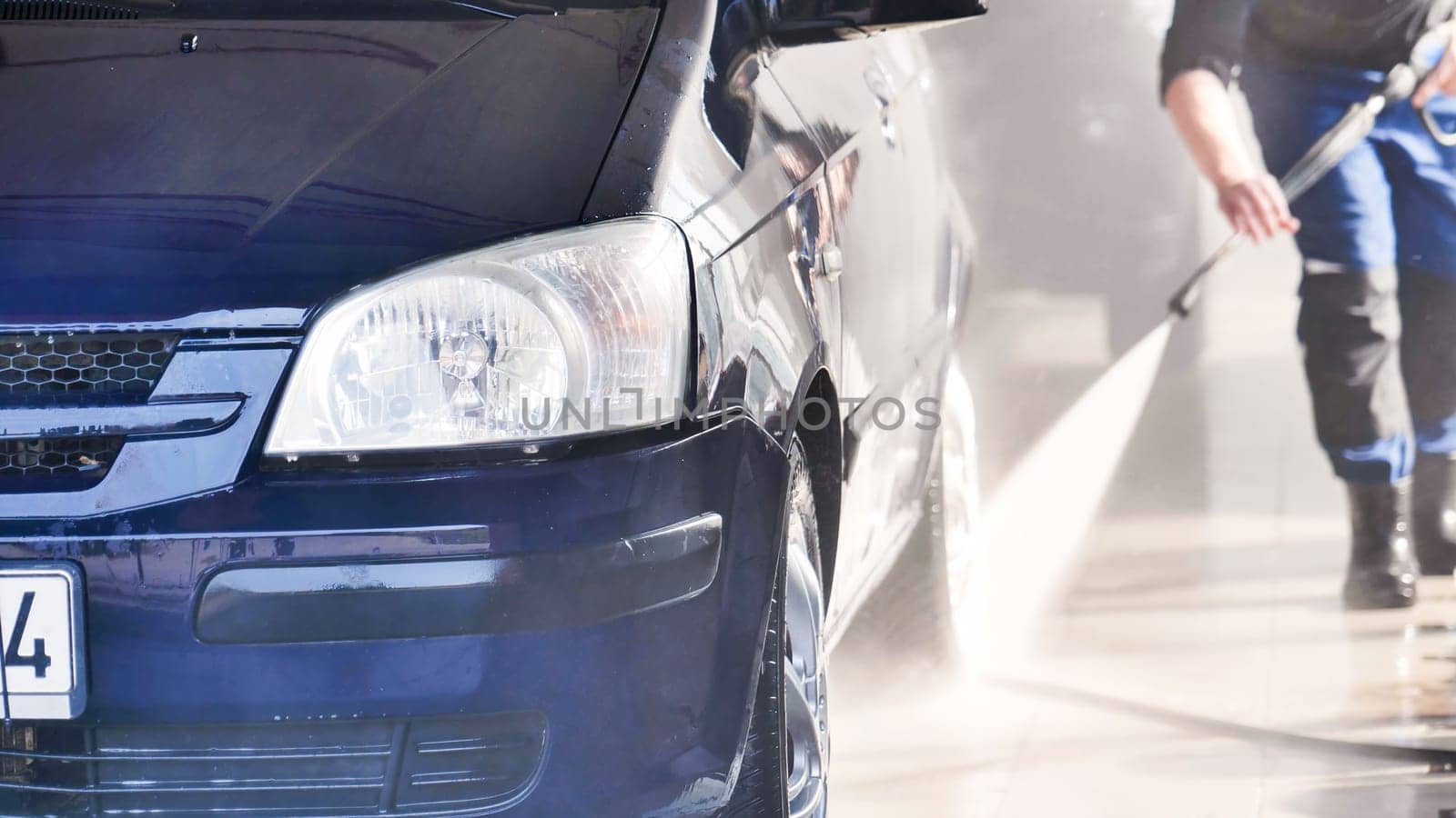 A close-up of a car headlight during a car wash