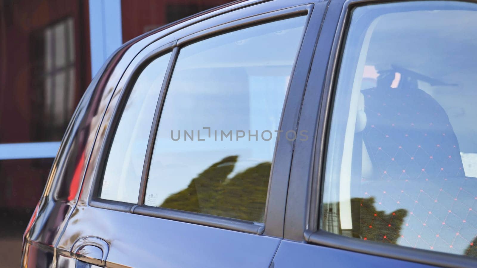 Clean car windows reflecting trees after car wash service