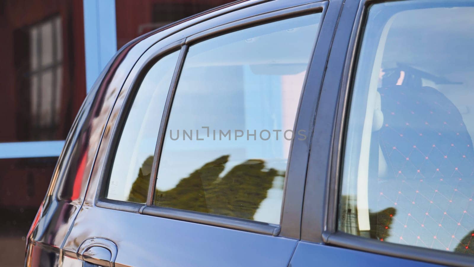 Shiny car reflecting surrounding buildings and trees after being washed