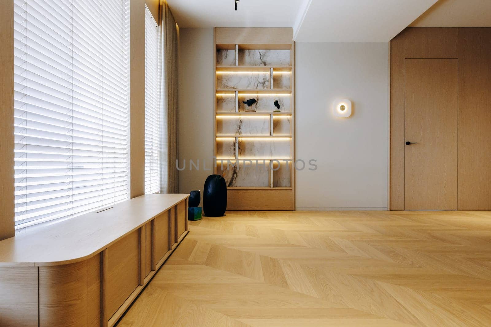 This cozy living room features a beautiful wooden floor, a stylish shelf for displaying items, and a window that brings in natural light