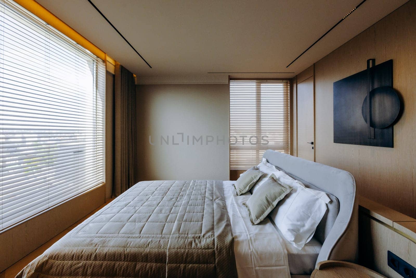 A cozy bedroom featuring a spacious large bed alongside a sizable window that brings in natural light and enhances the rooms overall ambiance