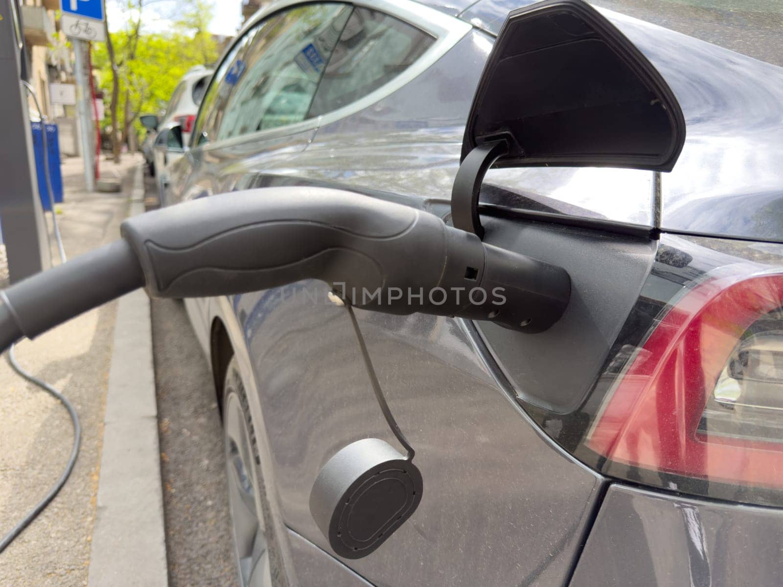 Close up of electric car charging highlights the transition to renewable energy and independence from fossil fuels, supporting cleaner, more responsible future with electric cars