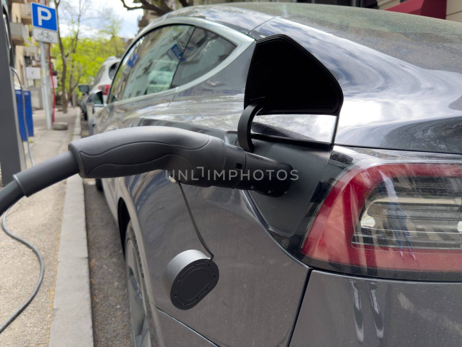 Electric vehicle recharging at public urban station, symbolizing eco friendly transport solutions, clean energy usage and the shift toward sustainable city infrastructure