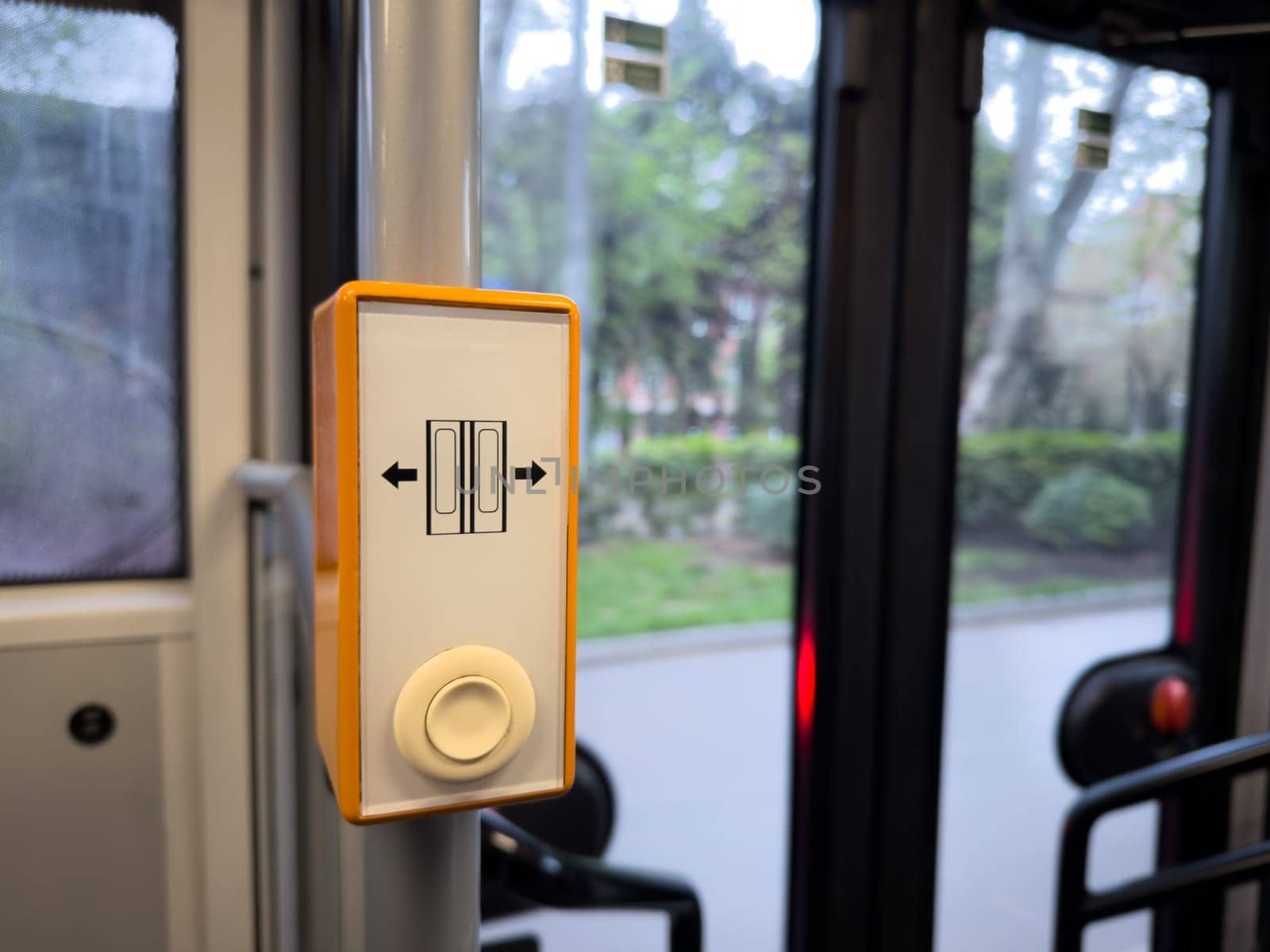 Detail of an automated door button inside a public transport vehicle, illustrating smart interface design and urban automation in everyday mobility systems. Push button in bus