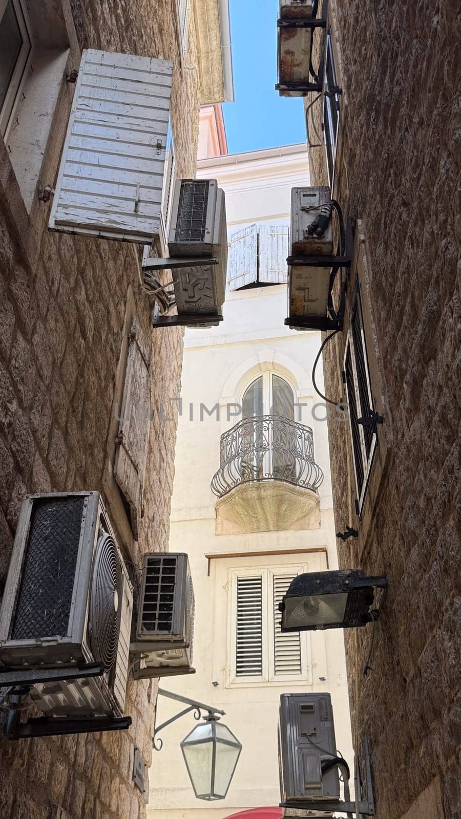 Budva, Montenegro - April 18, 2025: Urban architecture, air conditioning in a narrow alley, unique design elements of history and elements of modern urban life.