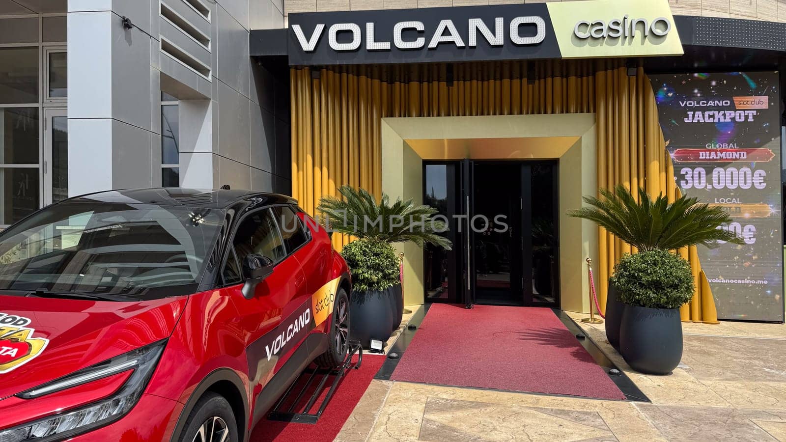Budva, Montenegro - April 18, 2025: Entrance to the Vulkan Casino with a luxury car parked next to it, highlighting the thrill and entertainment of the gameplay