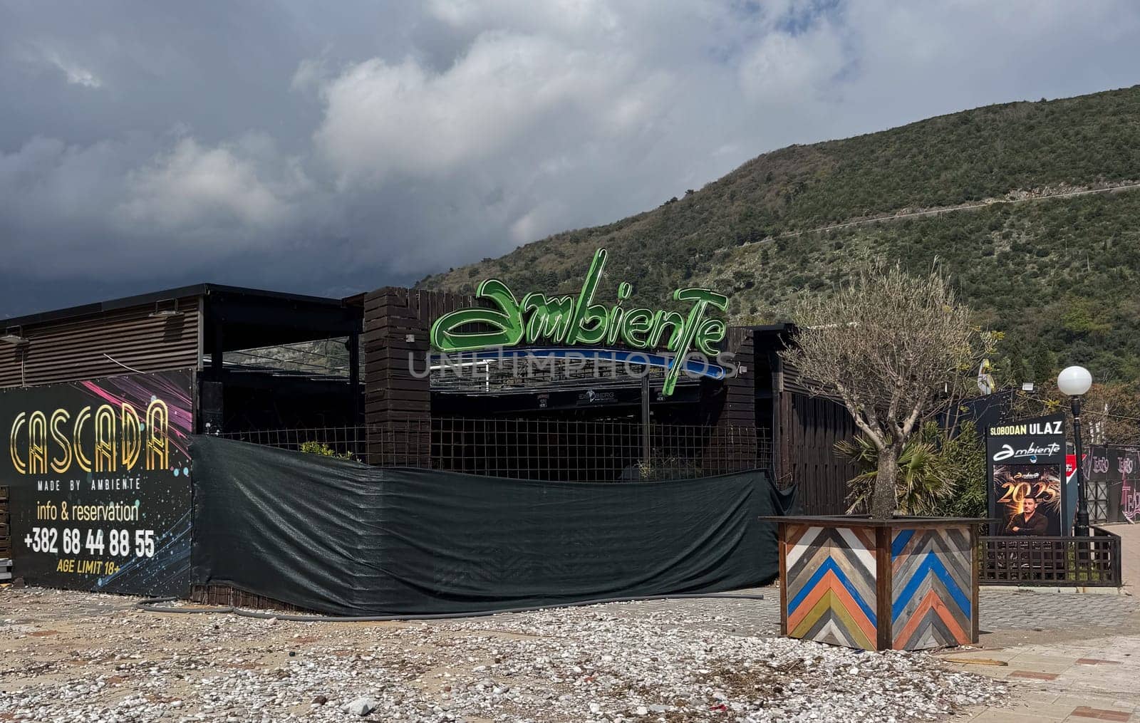 Budva, Montenegro - April 18, 2025: Located in Budva, the Cascada restaurant and bar with a bright sign and a closed net before the opening of the season