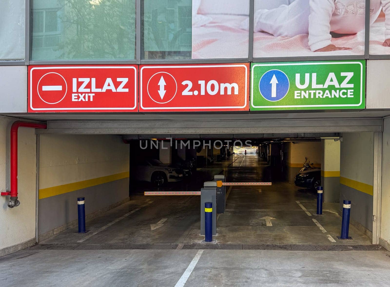 Budva, Montenegro - April 18, 2025: Signs above the entrance in the TQ Plaza parking lot give clear directions for vehicle navigation, showing drivers the entry and exit points