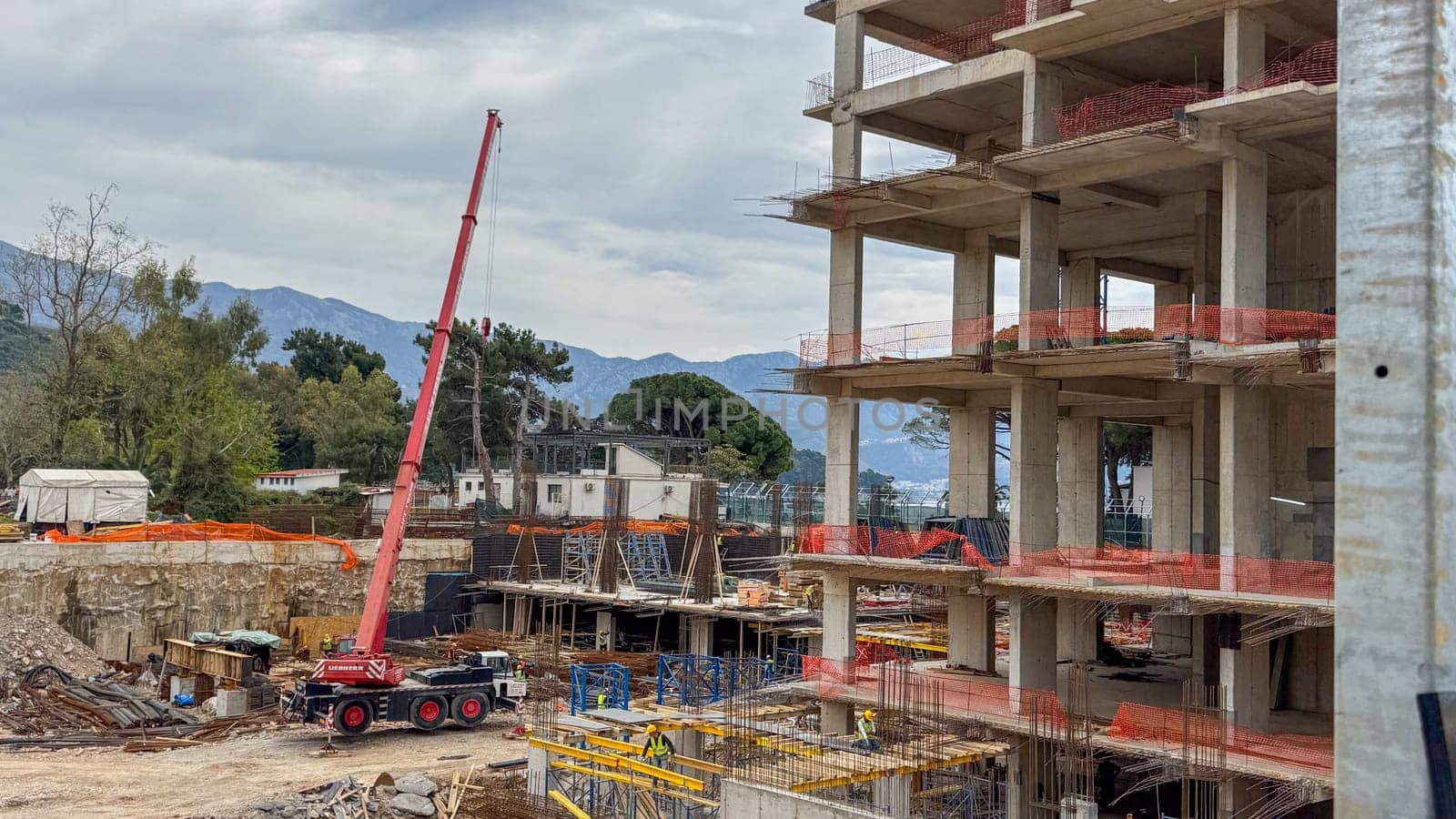 Budva, Montenegro - April 18, 2025: Swissotel construction site with crane lifting materials in an urban area