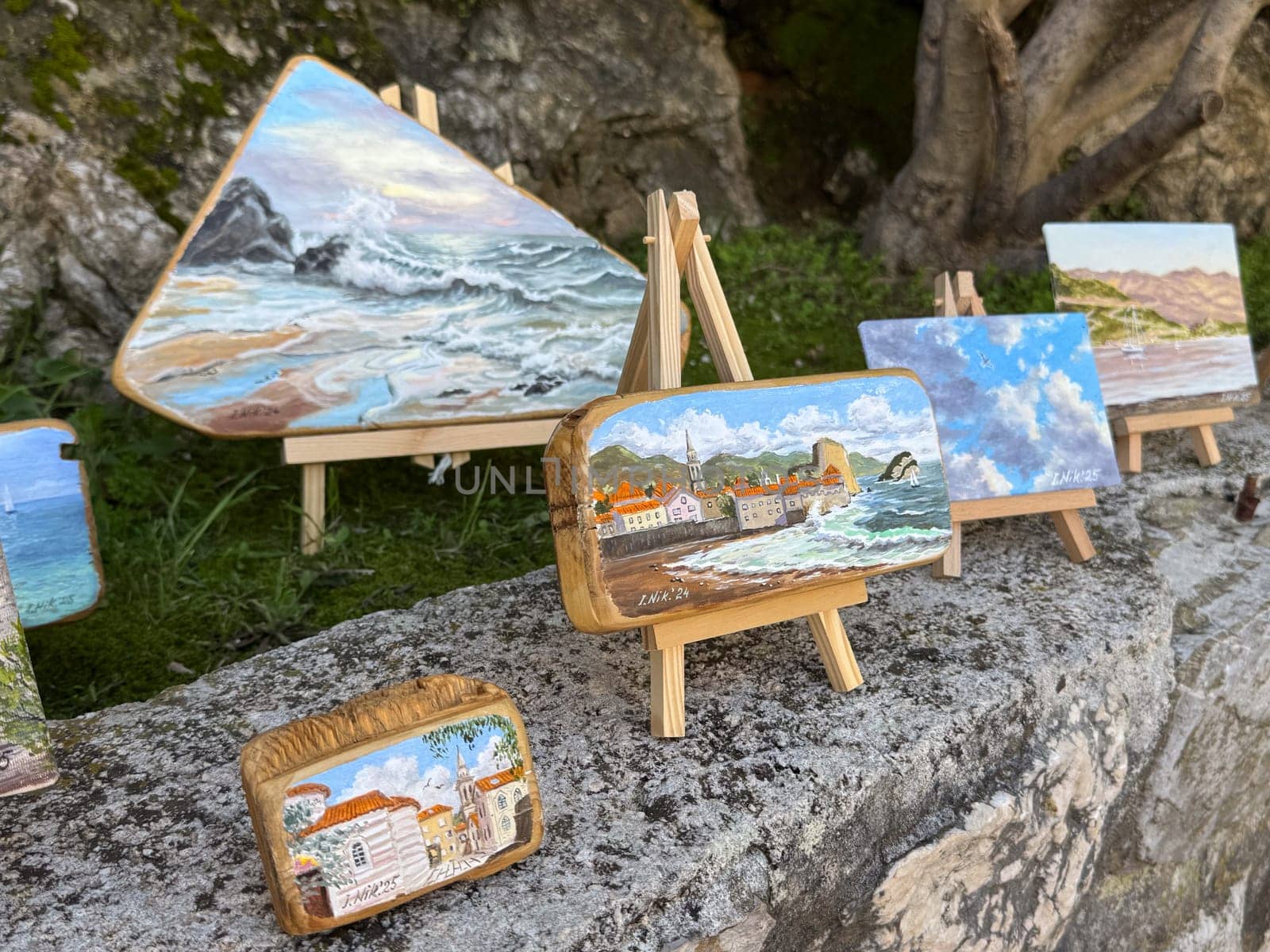 Budva, Montenegro - April 18, 2025: Art exhibition with painted stones and small canvases on easels, highlighting beauty and creativity