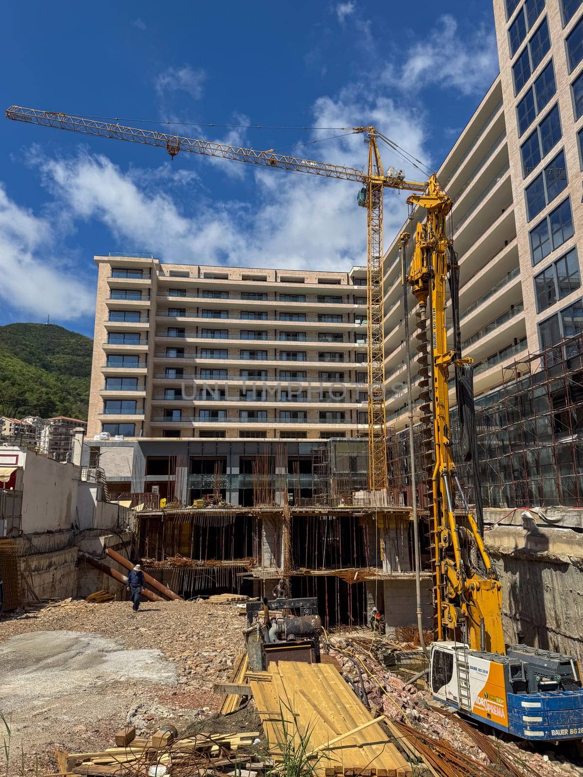 Budva, Montenegro - April 18, 2025: The hotel's construction site showcases the crane and building structure, highlighting the city's growth and progress in architecture and infrastructure