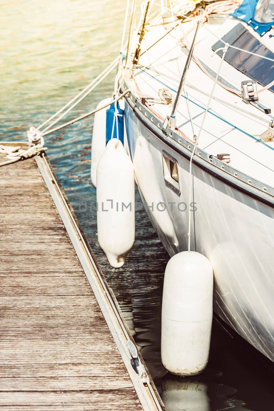 Sailboat moored at wooden dock, nautical scene in sunlight