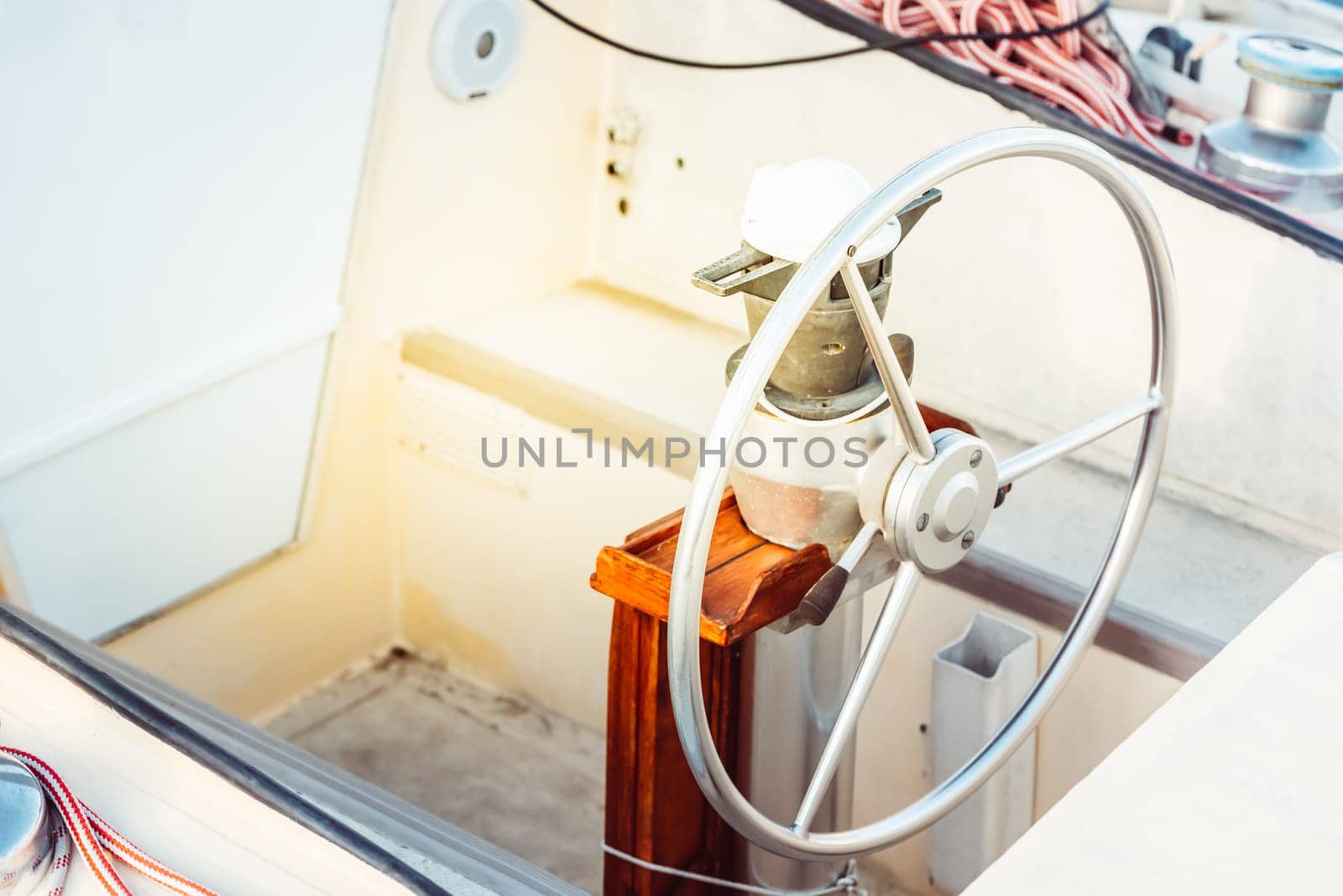 Sailboat steering wheel and deck with ropes in sunlight, suitable as a background