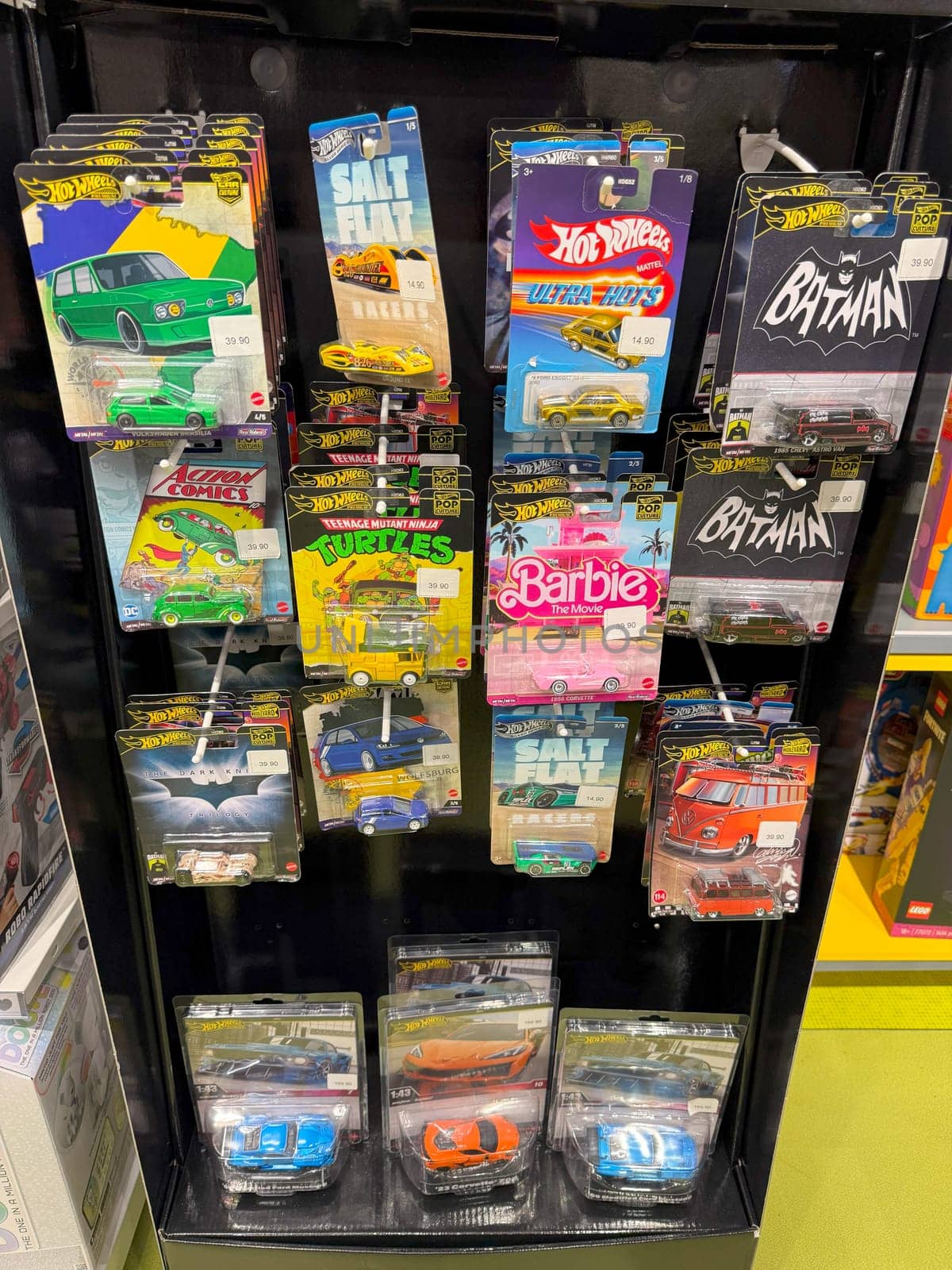 Tbilisi, Georgia, April 10, 2025: Display of Hot Wheels toy cars in packaging, featuring themed collections including superheroes, Barbie, and classic vehicles on store rack