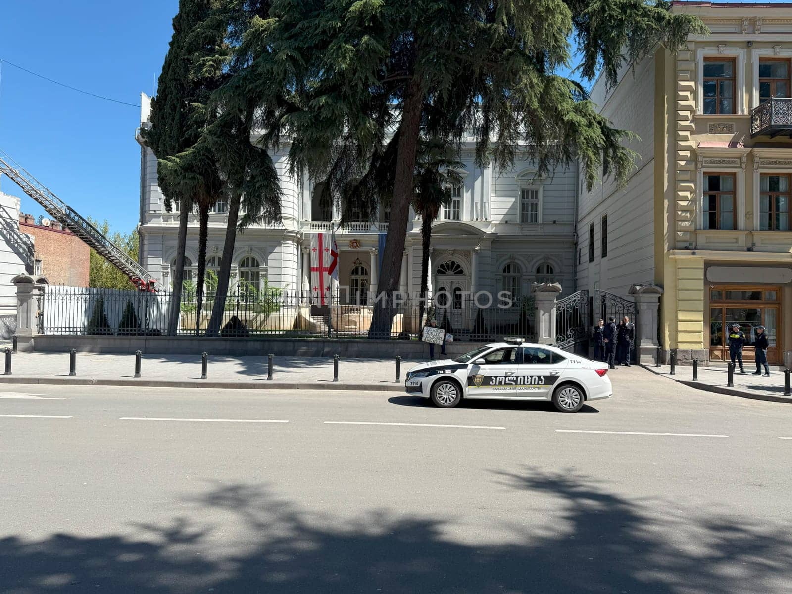 Tbilisi, Georgia, April 11, 2025: Lone man protests with sign in front of government building, while police stands nearby, guarding and overseeing the demonstration of just one individual