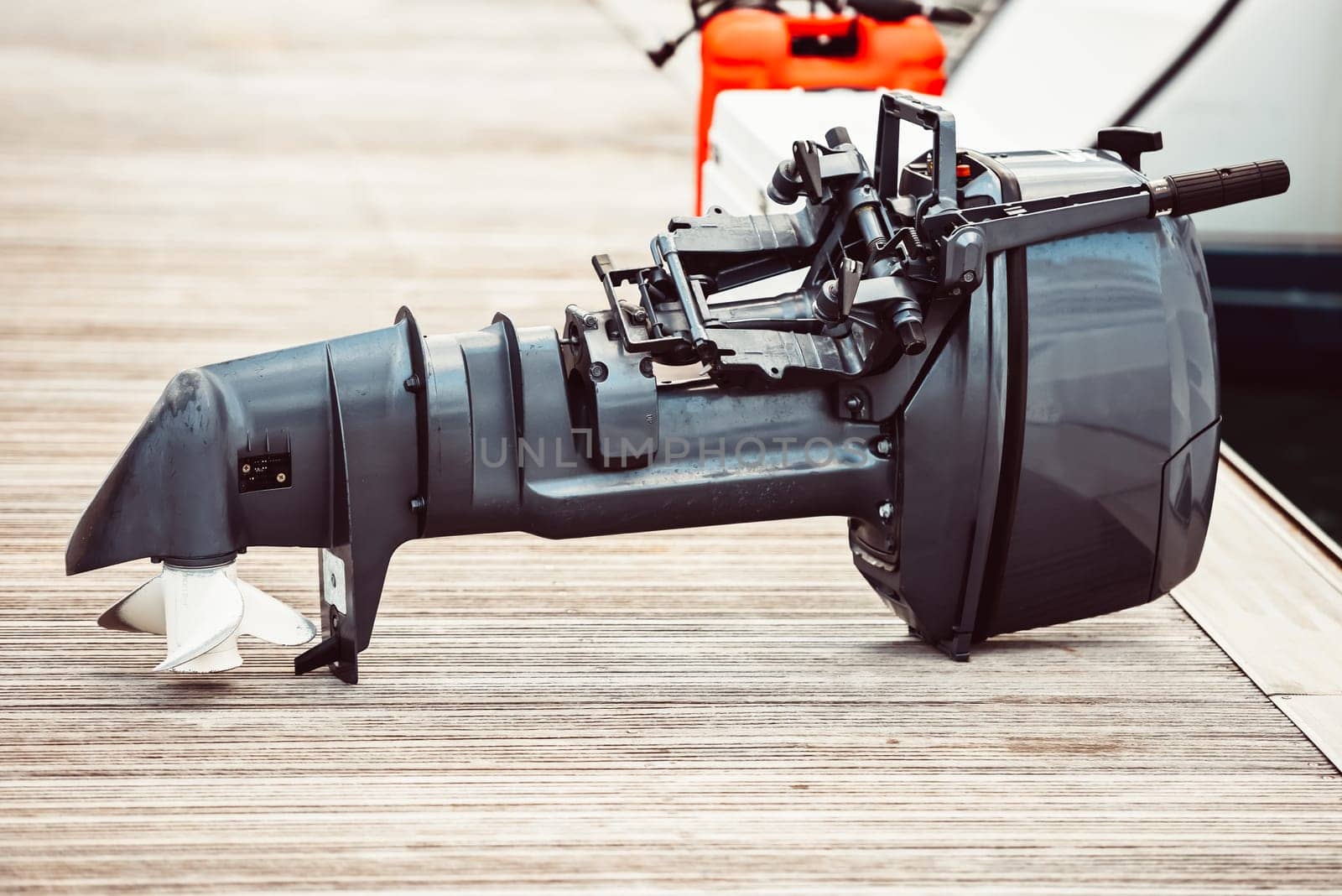 Boat motor on wooden dock near water, suitable for marine backgrounds
