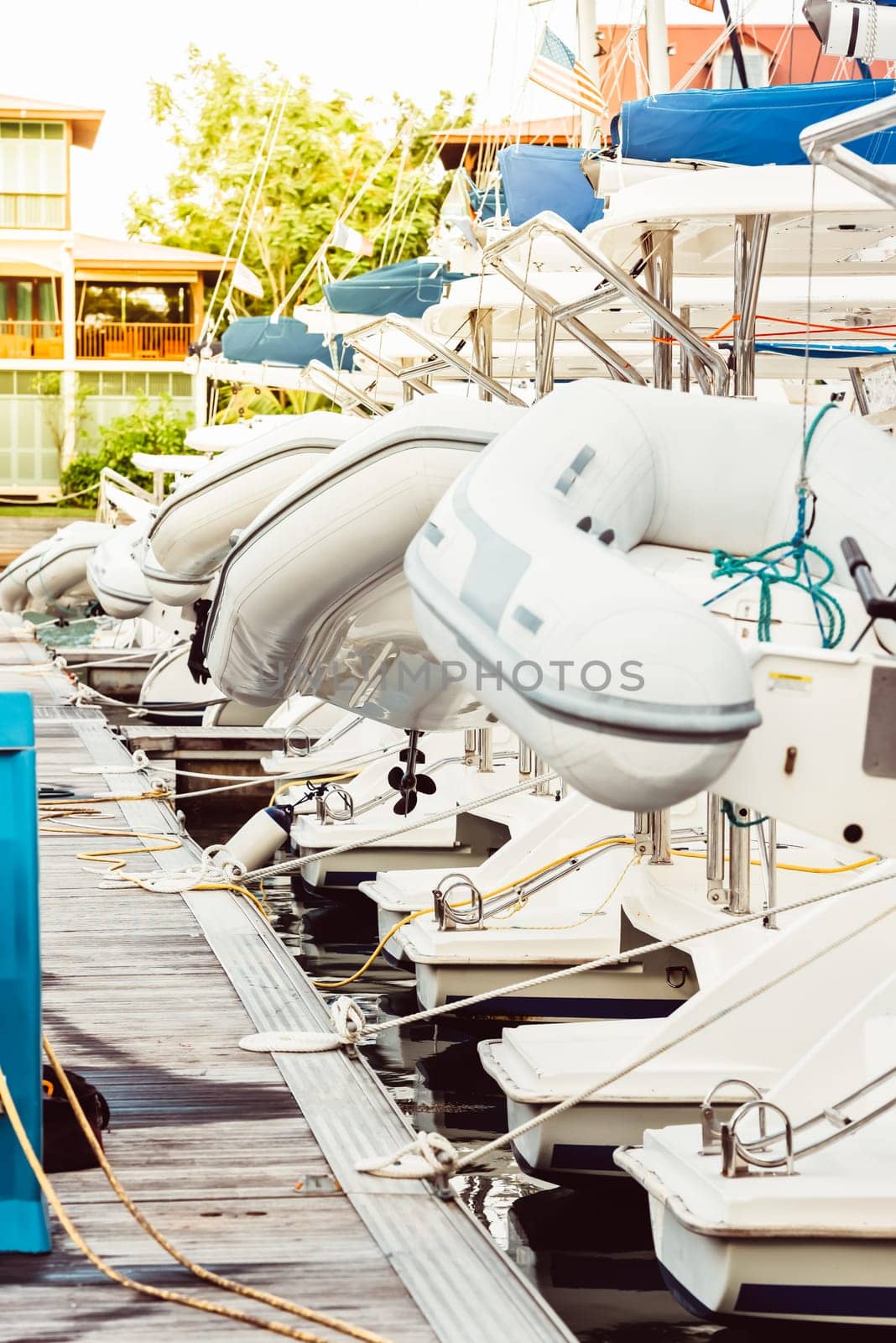 Boats docked at marina with white inflatables on sunny day