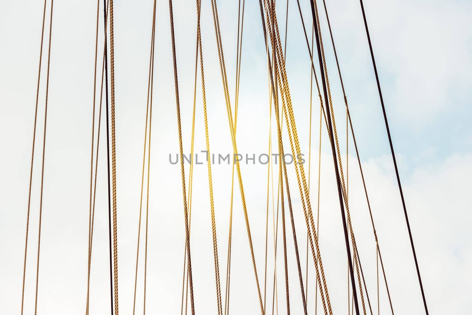 Rope cables against cloudy sky create industrial abstract pattern, background