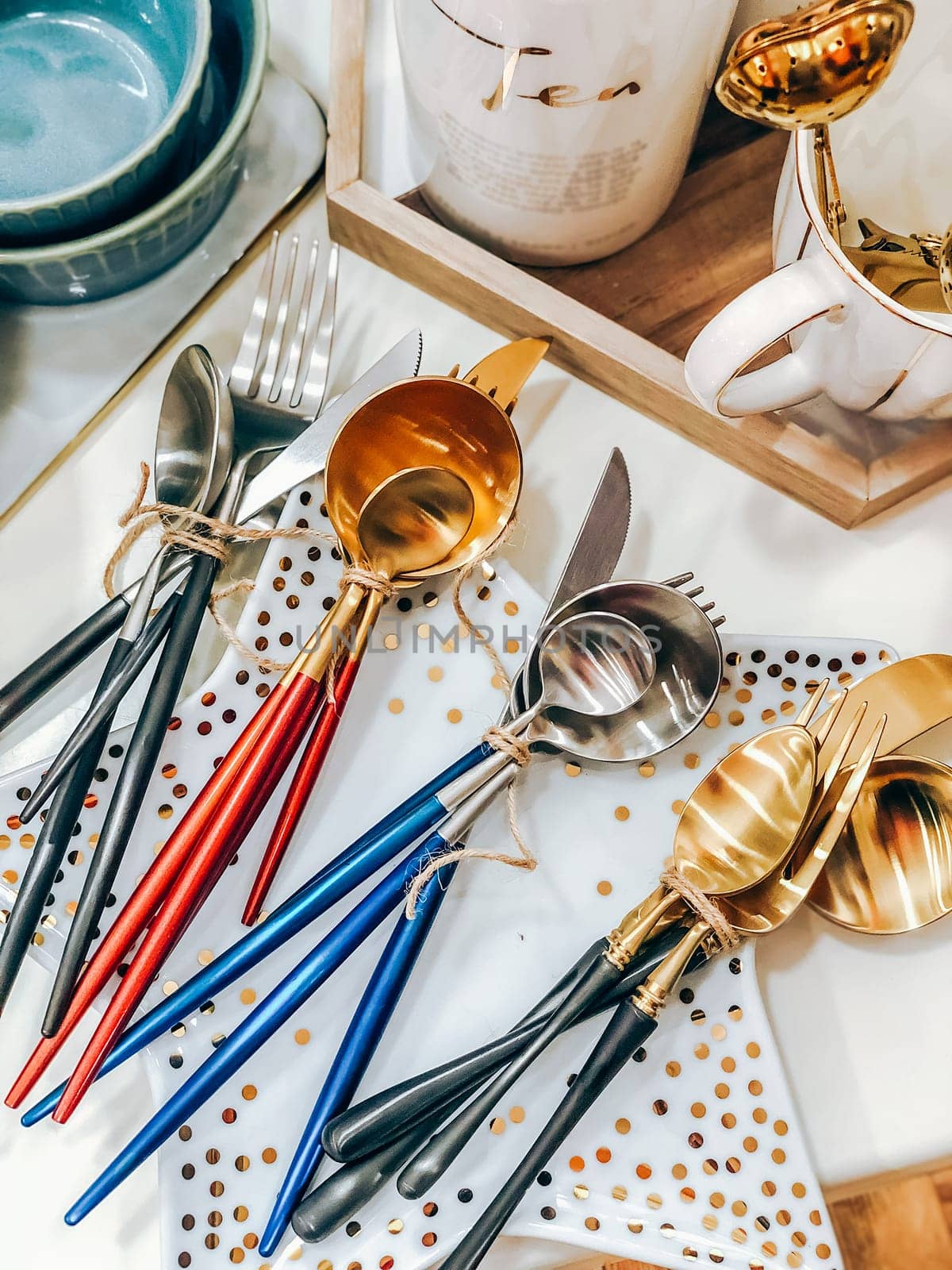 Colorful cutlery sets with wooden handles on white polka dot plates