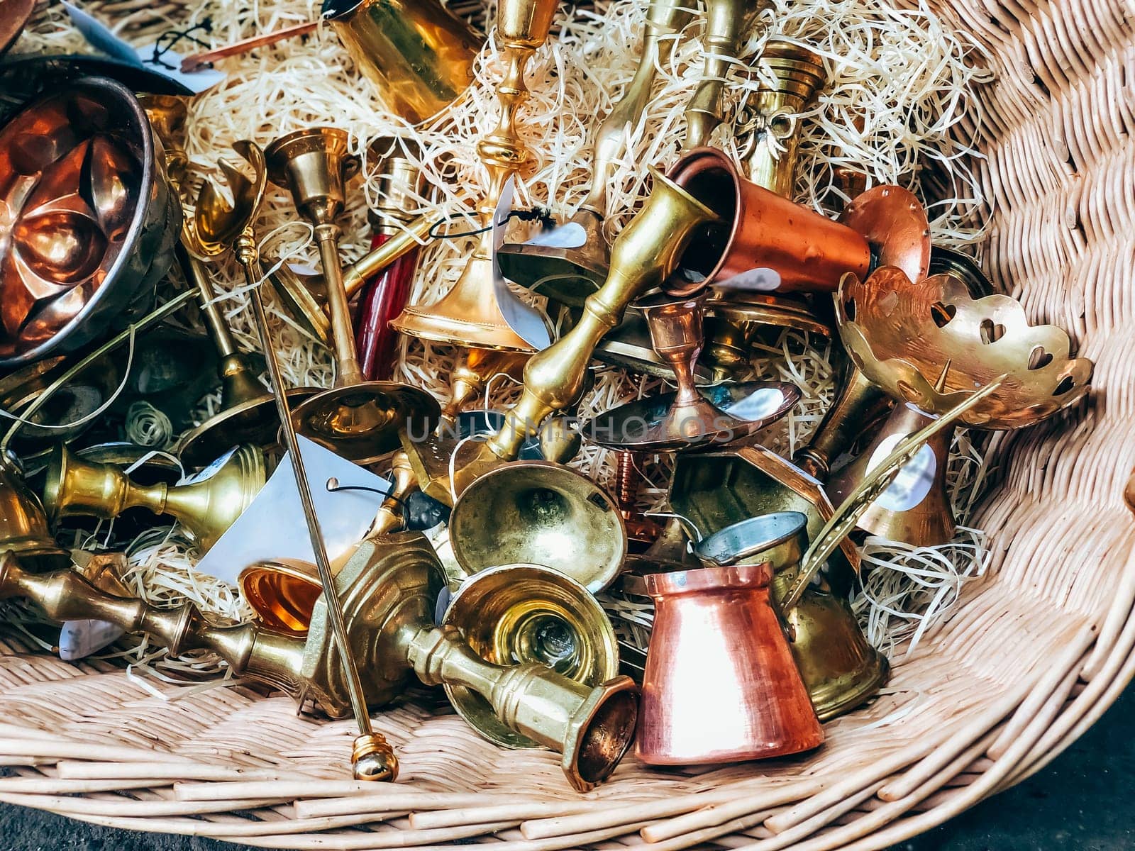 Antique brass and copper musical instruments in wicker basket, detailed texture